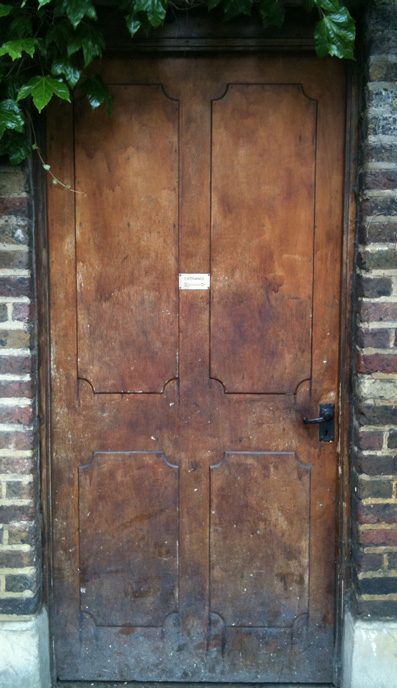 a wooden door with a brick wall