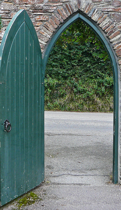 a turqoise door through a stonewall